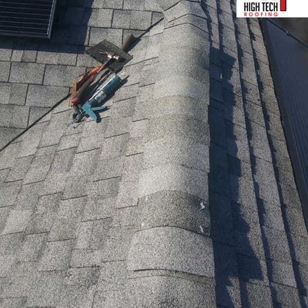 Roofing tools on asphalt shingles, showcasing a well-maintained roof structure.