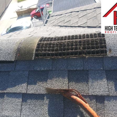 Roof maintenance image showing a damaged roofing shingle with a tool, highlighting repair needs.