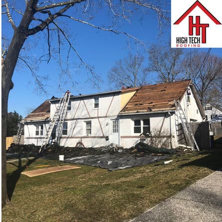 House undergoing roof repair with ladders, tarps, and High Tech Roofing logo visible.