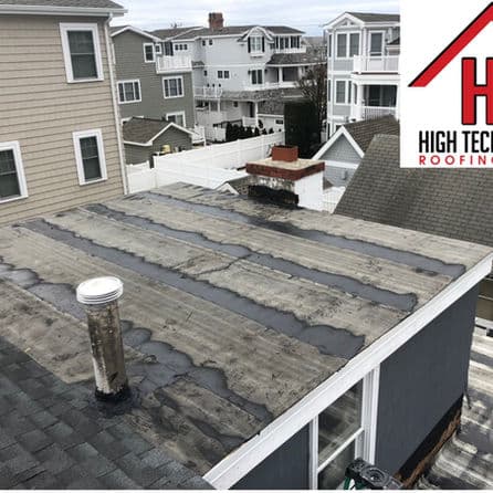 Flat roofing system with a chimney, showcasing wear and potential roofing needs.